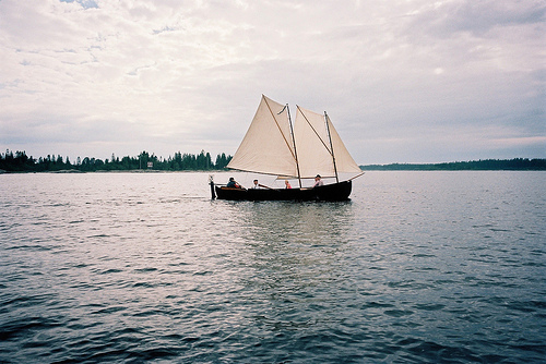 深蓝色彩日照海边帆船唯美风景图片