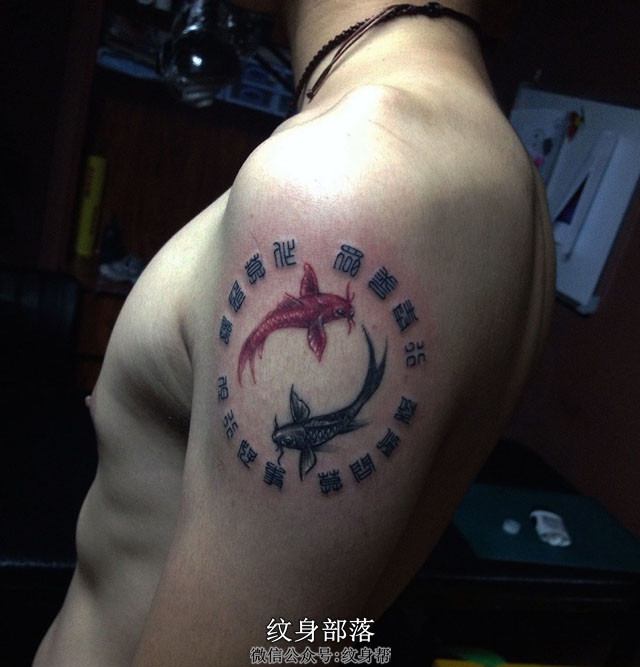 壮汉手臂上相互追逐的红黑鲤鱼刺青纹身
