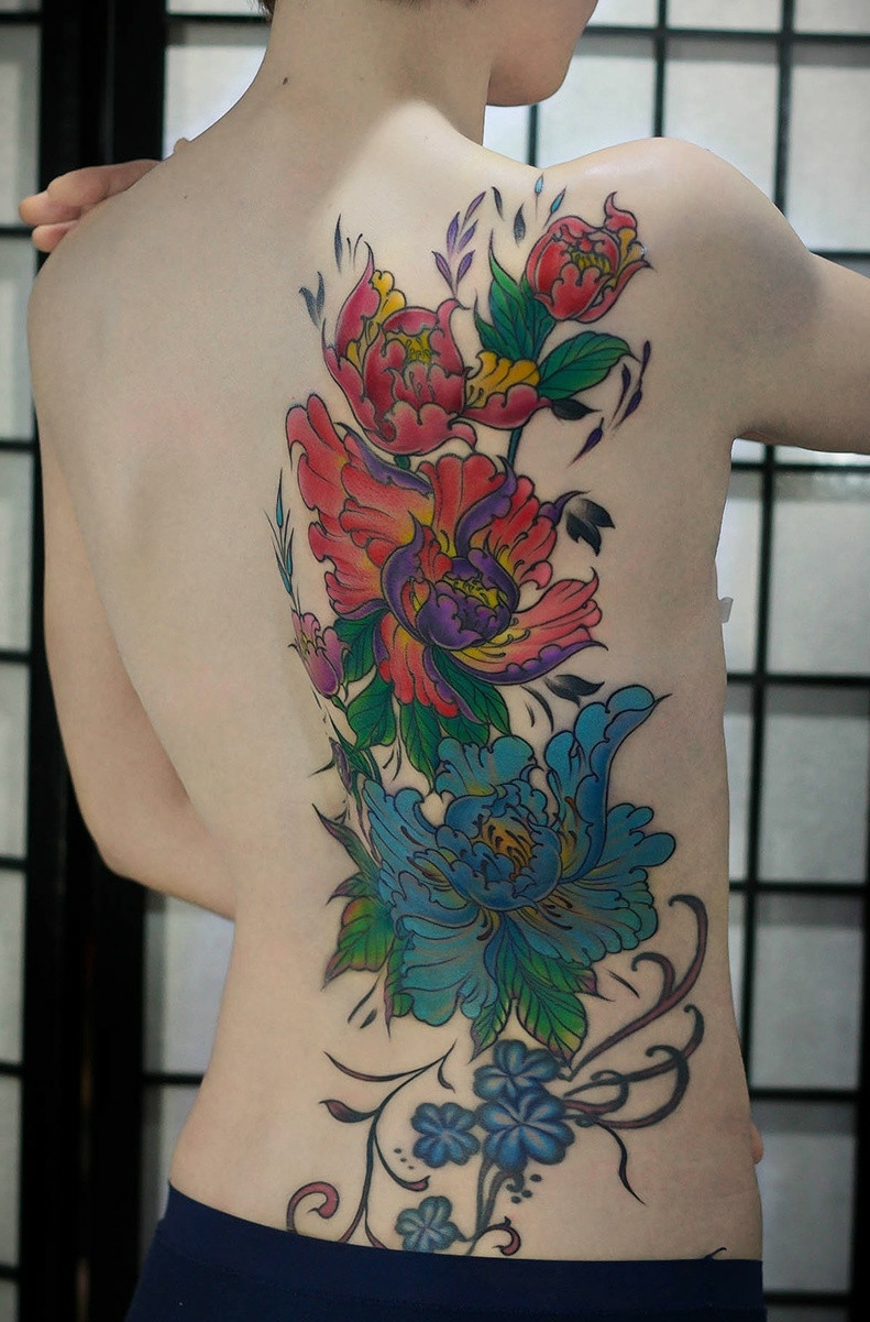 遮盖女生半边背部的彩色牡丹花纹身刺青